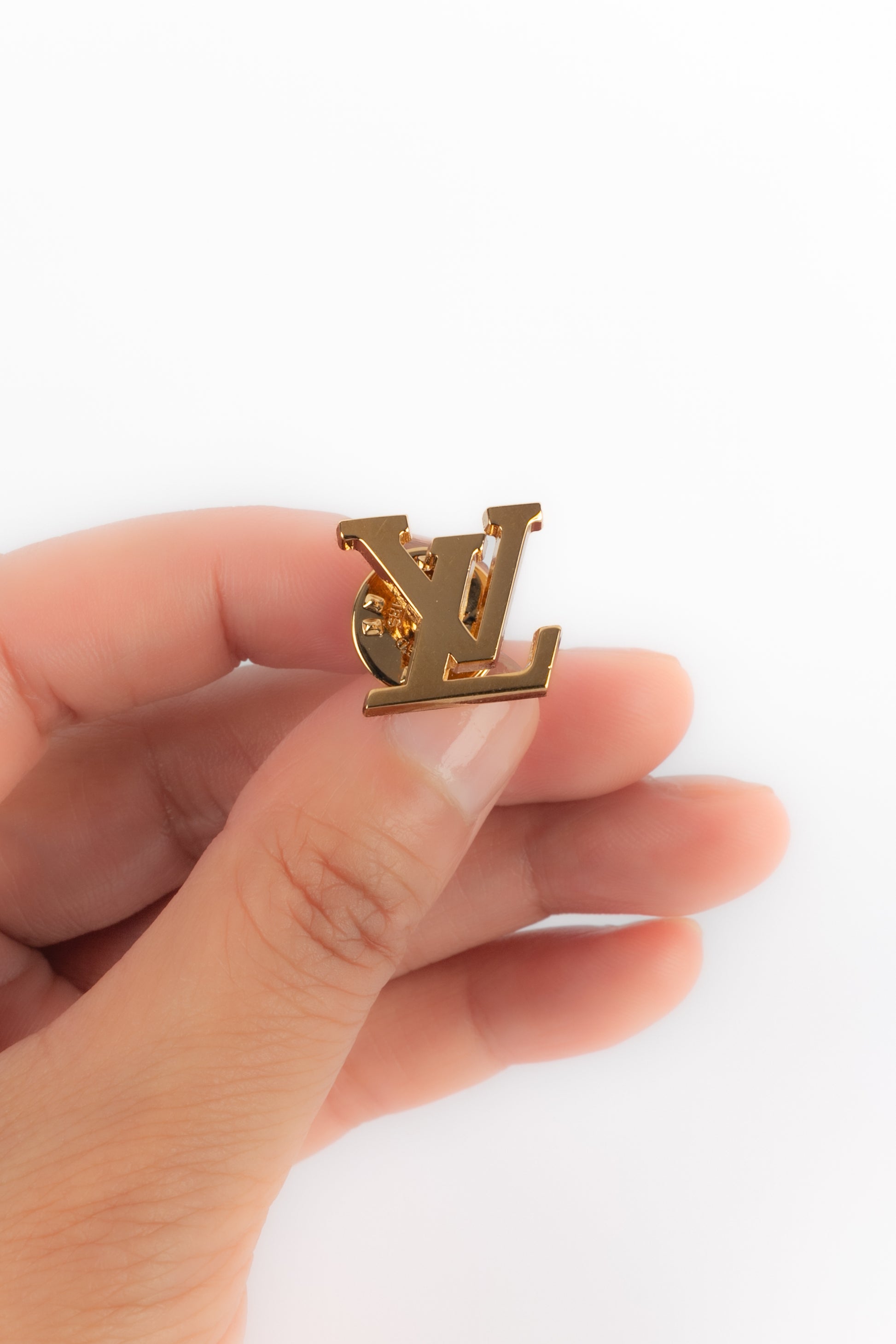 Pins LV en métal doré.